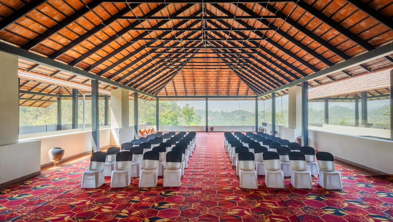 Spacious open-air venue featuring rows of seating under a wooden roof, ideal for events.