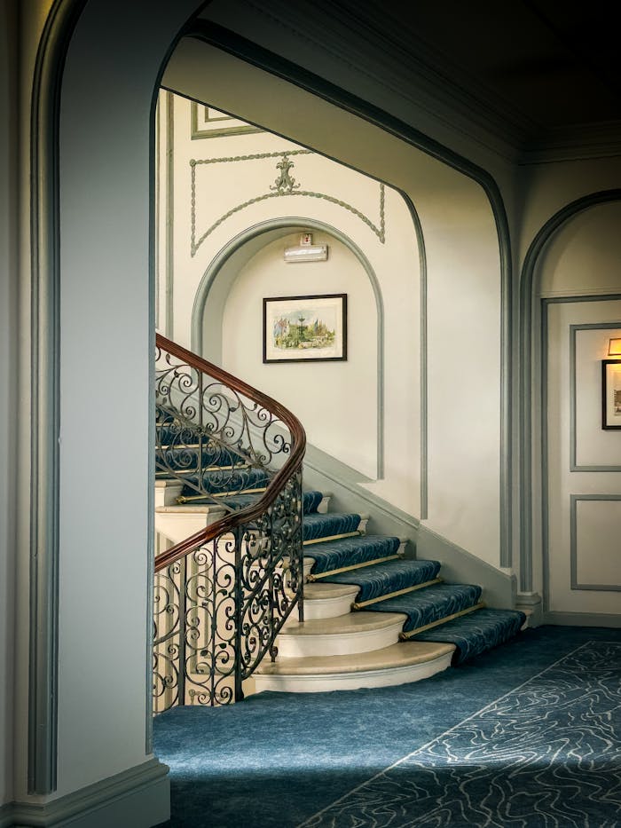 Sophisticated interior with a graceful curved staircase, ornate railing, and classic design accents.